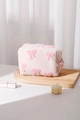 Détail d'une trousse de maquillage en peluche rose avec nœuds 3D sur un plateau en bois - 17x14cm / Sac Oreiller Rose