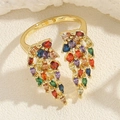 Vue macro d'une bague réglable dorée avec des pierres colorées en forme de feuille - Ouvert Réglable / Aile en zircone colorée dorée
