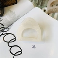 Detalle de una pinza para el cabello de resina translúcida crema sobre fondo de revista blanca - Mediano (aprox. 6cm) / Blanco Gelatina