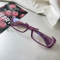 Detailed view of purple semi-rimless rectangular glasses on a silver laptop surface - Purple