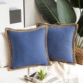 Detail of two blue linen pillow covers with beige braided trim on a cream sofa - Blue