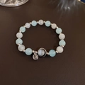 Detailansicht eines Perlenarmbands mit hellblauen Katzenaugensteinen und Silberanhängern - Blaues Katzenauge Elastisches Armband