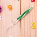 Creatieve spuit markeerstift met groene vloeistof op houten textuur achtergrond - Groen