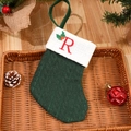 Green knit Christmas stocking with embroidered red letter R and festive decor - Letter R