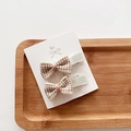 Detail of two plaid bow hair clips for girls on a white card display in a wooden tray - 2-Piece Set / Beige & Coffee Plaid