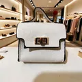 Detail of white lychee leather mini bag keychain with golden buckle and black oil edges - White Bag Style