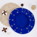 Close-up of blue wool beret featuring silver metal rings on woven placemat decor - 27.5*7cm / Sapphire Blue