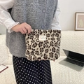 Cute leopard print plush cosmetic bag with brand label held in hand for travel - Beige Leopard