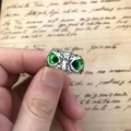 Vintage silver owl ring with green gemstone eyes shown against a retro script background - Green
