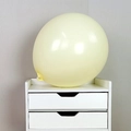 Creamy yellow macaron latex balloon displayed on a white drawer with a matte finish - 18 Inch Macaron Yellow