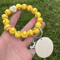 Nordic style softball beaded wristlet keychain with natural wood pendant on green grass - Yellow Softball Style