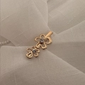 Dettaglio di fermaglio dorato con design a doppio fiore e centri in zircone - Design a Doppio Fiore / Oro