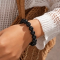 Nahaufnahme eines minimalistischen schwarzen Perlenarmbands am Handgelenk - Armband / Schwarz