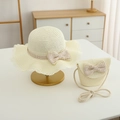 Detail of cream straw sun hat with wavy brim and matching bow handbag set for kids - Hat + Bag Set / Creamy White