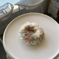Détail d'un chouchou en tissu rayé aux couleurs pastel avec texture plissée sur une assiette - Brun et Blanc
