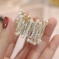 Detailed close-up of high ponytail shark clip with pearls and sparkling rhinestones - Crown Mixed Diamond Gold Claw