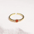 Close-up of adjustable gold-plated ring featuring a round orange zircon and side diamonds - Red Zircon Gold