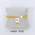 Golden beaded bracelet with white heart enamel pendant and pearl on display pillow - White Heart Charm Bracelet (Gold)