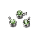 Close-up of three round stainless steel pendants with faceted green zircon stones - 10 Pieces per Pack / Steel Border Green Stone