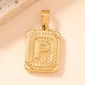 Macro detail of square gold stainless steel pendant with letter P and sunburst texture - Letter P
