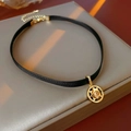 Detail der schwarzen Bandhalskette mit goldenem Sternanhänger und funkelndem Kristall - Gold-Schwarz