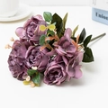 Close-up of purple artificial rose bouquet with silk petals and green leaves on white desk - Purple