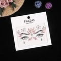 Detail of pink and silver acrylic face gems with eye pattern packaging on black background - Pink