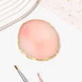 Detailed top view of pink resin agate nail palette with gold rim on white background - Pink