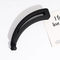 Macro detail of the black matte texture and twisted design on the banana hair clip - Black