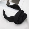 Detail eines schwarzen Stoffstirnbands mit großer Seidenblume auf weißem Grund - Schwarz