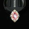 Macro shot of oval pink gemstone brooch with golden filigree and crystal accents - Gold Pink