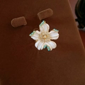 Detailed close-up of a vintage floral ring with white petals and turquoise bead accents - Flower Ring