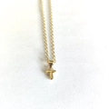 Detailed view of a minimalist gold necklace with a delicate letter T pendant on white paper - Letter T