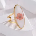 Detalle macro de anillo ovalado con flor preservada y banda dorada doble ajustable - Forma Ovalada Rosa Naranja (OLBR703-A)