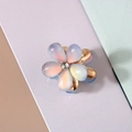 Détail d'une pince à cheveux fleur en résine bleue avec un centre en strass brillant - Style Œil de Chat en Résine / Bleu