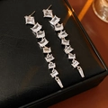 Macro detail of long silver fringe earrings with shimmering square-cut zirconia stones - Silver (Silver Pin)