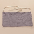 Detail of purple cotton storage bag with two pockets and white ties on soft beige backdrop - Light Purple