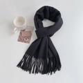 Flat lay of a stylish black scarf with elegant tassel details on a clean white desk - Regular Fit / Solid Black