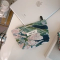 Detailed top view of a dark green jacquard floral storage pouch with a simple wish label - Chenille Dark Green Leaves