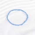 Detailed close-up of blue beaded bohemian bracelet on a white minimalist textured surface - Dark Blue