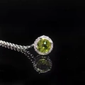 Dettaglio macro del ciondolo in argento con gemma verde e contorno di brillanti - Peridoto