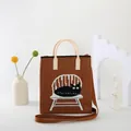Detailed view of knitted tote bag featuring a black cat pattern with a woven shoulder strap - Coffee {Windsor Cat}