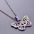 Macro detail of rainbow plated butterfly pendant with intricate scrollwork cutouts - Pendant Necklace / Rainbow