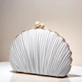 Detail of silver shell evening clutch with pleated texture, pearls, and gold metal frame - Silver