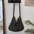 Detail des Blumenmusters auf schwarzer Umhängetasche in minimalistischer Wohnumgebung - Schwarz mit grünem Herz