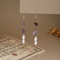 Detail of butterfly pearl tassel earrings featuring purple stones on vintage book background - E6407 (Purple Stone/Pearl Stacked)