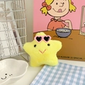 Close-up of yellow plush star pendant with pink heart sunglasses on a warm background - Yellow Star with Heart Sunglasses