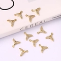Detail shot of golden fish-tail pendants with cubic zirconia inlay on a white surface - Fish Tail 11*11mm