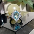Silver ring with teardrop blue gemstone and zircon halo on a reflective surface - Jz885【cuic Blue Diamond】ljz-211 / Adjustable Open