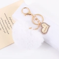 Close-up of white faux fur heart keychain with gold I Love You pendant and rhinestones - White